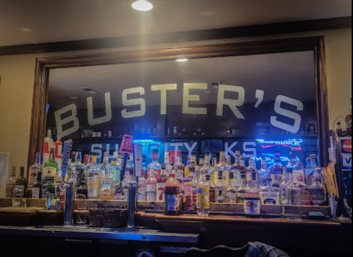 A bar with a mirrored backdrop displaying various liquor bottles and the name "Buster's" prominently featured.