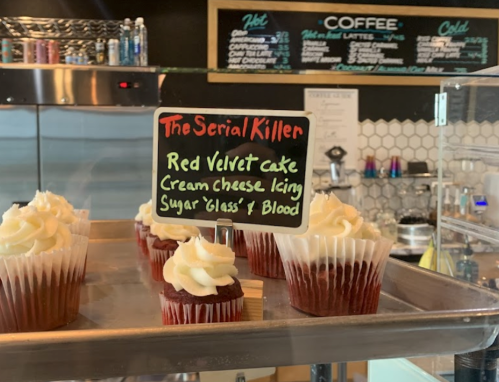 A display of red velvet cupcakes with a sign reading "The Serial Killer" and ingredients listed.