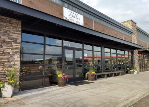 Exterior of Belles Brunch House with large windows, planters, and a sign above the entrance.