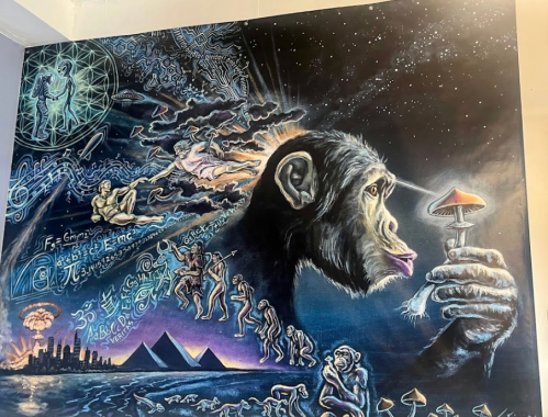 A vibrant mural featuring a monkey holding a mushroom, surrounded by cosmic and evolutionary imagery.