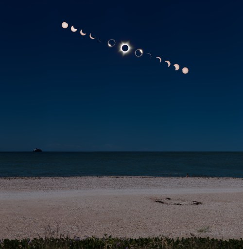 A sequence of lunar phases above a calm sea, culminating in a total solar eclipse against a dark sky.