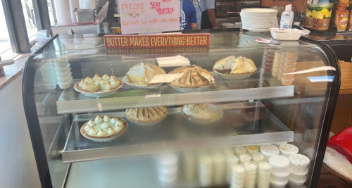 A display case filled with various pies and desserts, with a sign that says "Butter makes everything better."