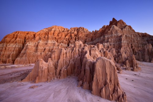 Stunning rock formations in warm hues under a clear blue sky, showcasing the beauty of a desert landscape.