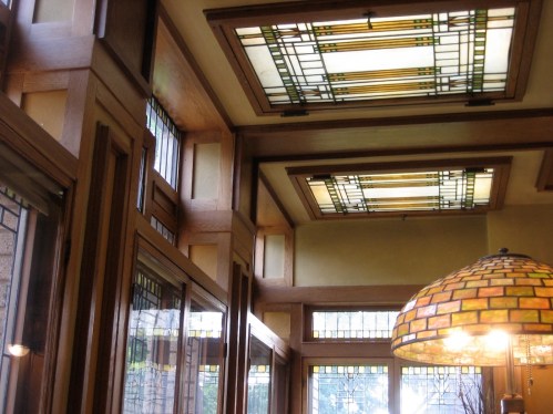 Interior view featuring stained glass windows and a decorative lamp, showcasing a warm, artistic design.