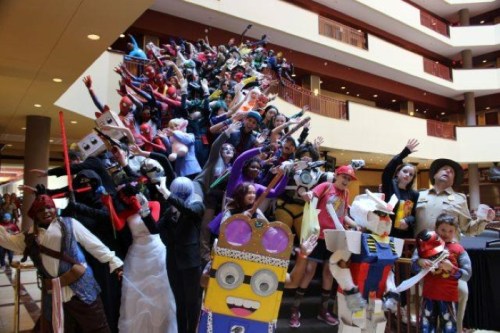 A large group of people in colorful costumes poses on a staircase, showcasing various characters and themes.