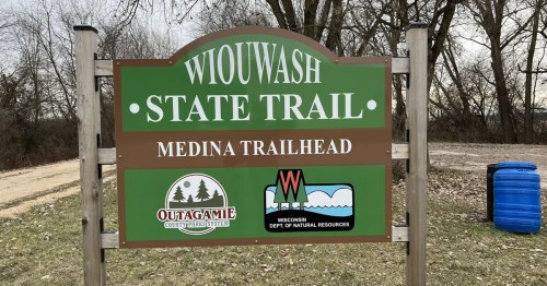 Sign for Wiouwash State Trail at Medina Trailhead, featuring logos for Outagamie County Parks and Wisconsin DNR.