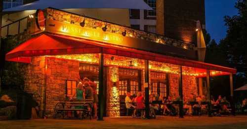 A cozy bistro illuminated at night, with people dining outside under warm lights and a welcoming atmosphere.