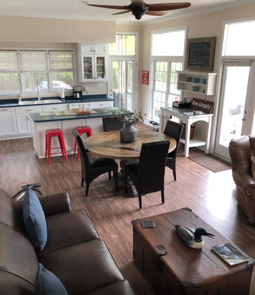 Cozy living space with a kitchen, dining table, and seating area, featuring natural light and modern decor.