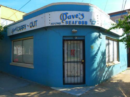 A blue seafood carry-out restaurant with a sign reading "Dave's Seafood" and a black door.