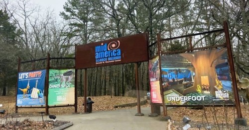Entrance to Mid-America Science Museum, featuring colorful banners for exhibits like "Dino Rides" and "Underfoot."