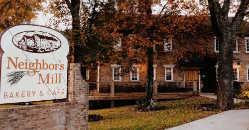 A cozy bakery and café named Neighbor's Mill, surrounded by autumn foliage and a welcoming entrance.