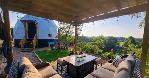 Cozy outdoor seating area with a view of a dome structure and lush greenery in the background.
