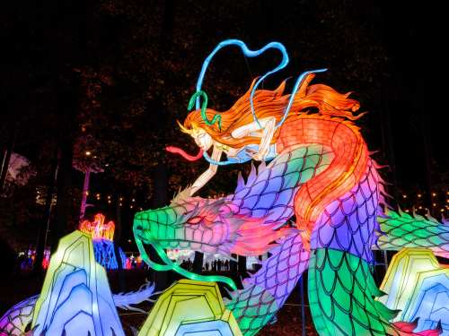 A vibrant lantern display featuring a dragon and a woman with flowing hair, illuminated in colorful lights.