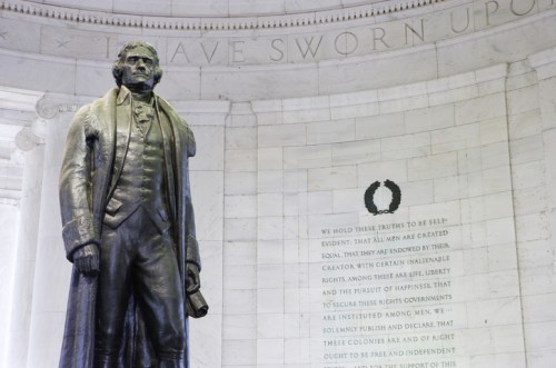 Statue of Thomas Jefferson inside the Jefferson Memorial, with inscribed text on the wall behind him.