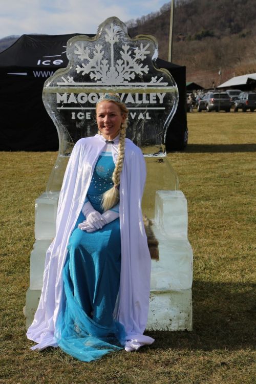 A woman in a blue dress and white cape sits on an ice throne at the Maggie Valley Ice Festival.