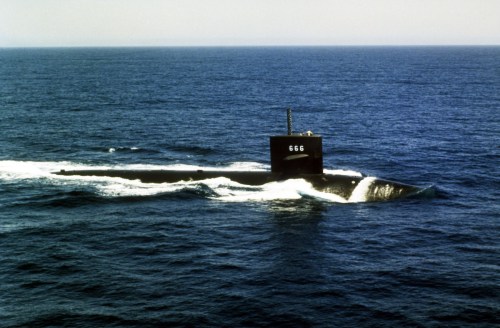 A submarine with the number 666 navigates through calm ocean waters, leaving a wake behind it.