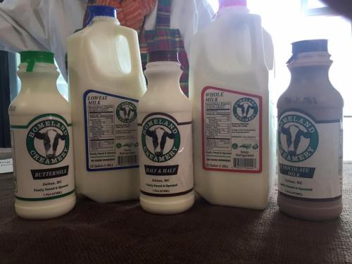 Five milk bottles from Homeland Creamery, including buttermilk, low-fat, whole milk, half & half, and chocolate milk.