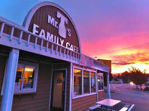 A cozy café with a sign reading "Mr. T's Family Café" against a vibrant sunset sky.