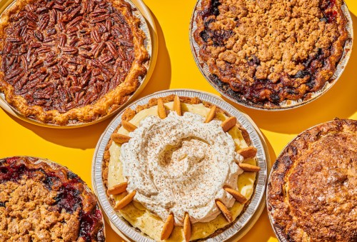 A colorful assortment of five pies on a bright yellow background, featuring pecan, banana cream, and fruit pies.