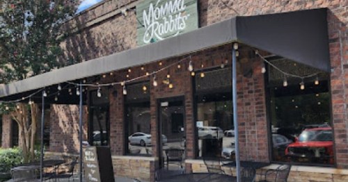 Exterior of a restaurant named "Momma Rabbits," featuring a patio with string lights and outdoor seating.