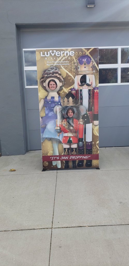 A promotional display featuring two cutouts for people to pose as a king and queen, with festive decorations.