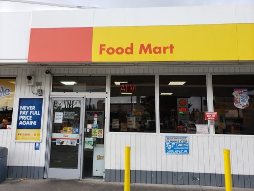 Exterior of a Food Mart with an ATM sign, featuring colorful signage and a welcoming entrance.