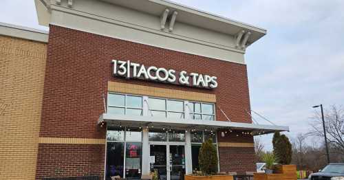 Exterior of 131 Tacos & Taps restaurant, featuring a modern design and "OPEN" sign in the window.