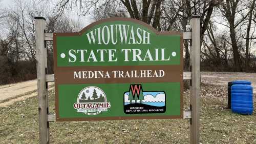 Sign for Wiouwash State Trail at Medina Trailhead, featuring logos for Outagamie County Parks and Wisconsin DNR.