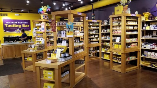 A vibrant mustard tasting bar with wooden displays, jars of mustard, and a welcoming atmosphere.