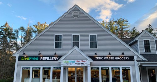 Exterior of a store with signs for "LiveFree Refinery" and "Zero Waste Grocery," featuring a welcoming, modern design.