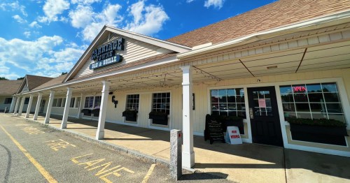 Exterior of a bar and grill with a sign reading "Cattail Cove," featuring a welcoming entrance and open sign.