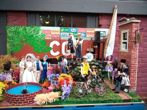 A colorful display of dolls depicting a lively scene with a band, a wedding, and various characters in a garden setting.
