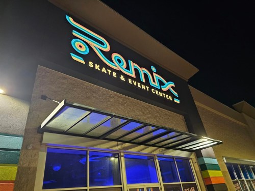 The exterior of Remix Skate & Event Center at night, featuring a brightly lit sign and colorful wall accents.