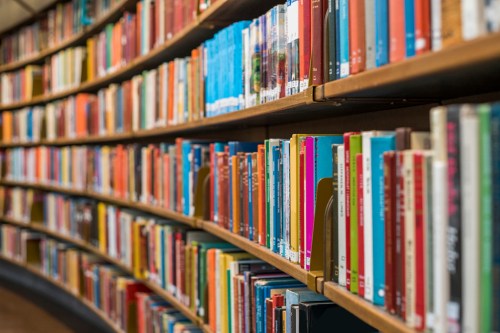 A close-up of a curved bookshelf filled with colorful books in a library.