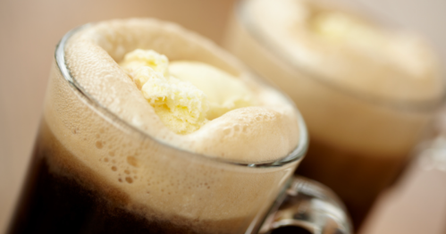Two glasses of root beer float topped with creamy ice cream and frothy bubbles.