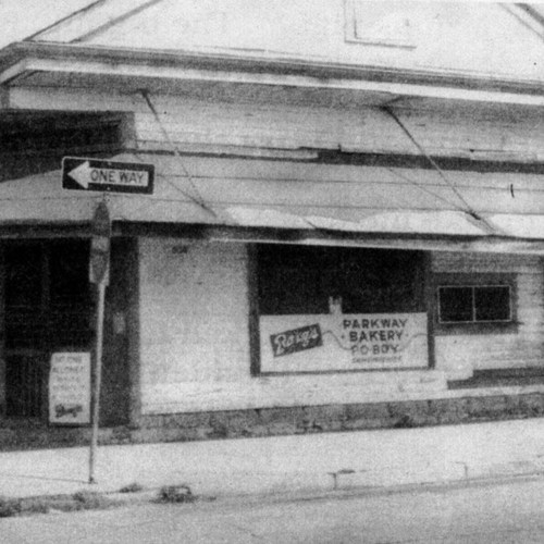 Black and white image of a bakery storefront with a "One Way" sign and a visible sign for Parkway Bakery.