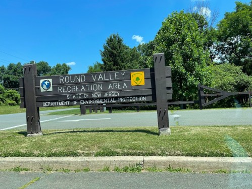 Sign for Round Valley Recreation Area in New Jersey, featuring state and environmental protection logos.