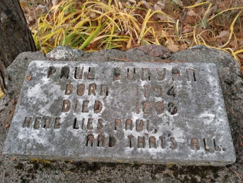 Gravestone for Paul Bunyan, born 1794, died 1884, with inscription: "Here lies Paul, and that's all."