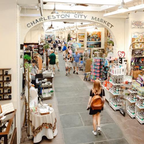 A bustling market scene with shoppers exploring various stalls and products in Charleston City Market.