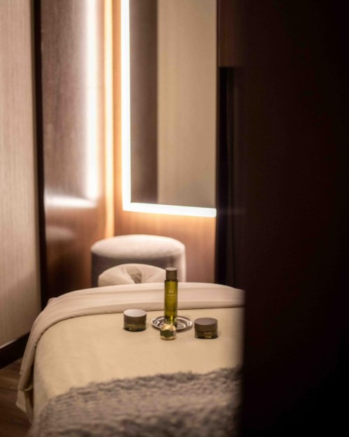 A serene spa setting featuring a massage table, skincare products, and soft lighting for relaxation.