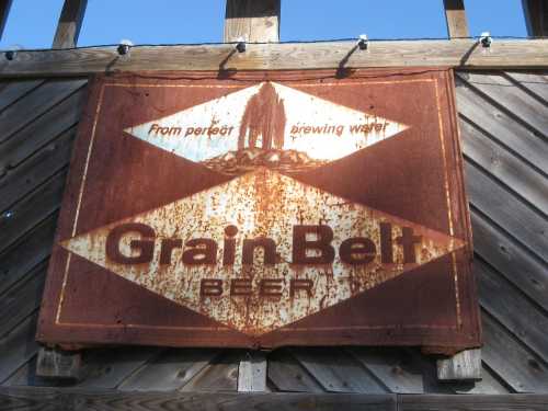 Rusty vintage sign for Grain Belt Beer, featuring a diamond design and the text "From perfect brewing water."