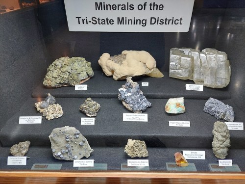 Display of various minerals from the Tri-State Mining District, showcasing unique textures and colors.
