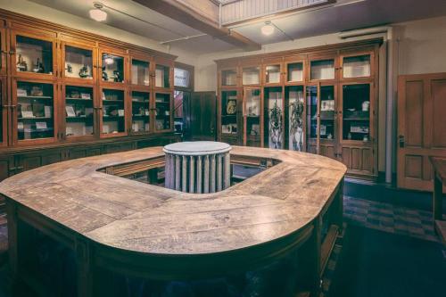 A wooden table in a museum-like room with display cabinets and a central column, showcasing various artifacts.