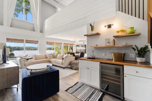 Bright, modern living space with a kitchen, cozy seating area, and large windows overlooking a scenic view.