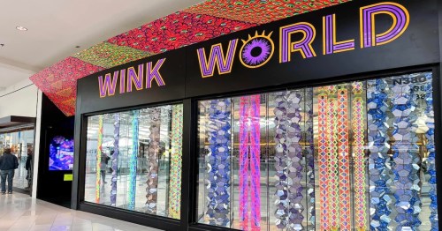 A colorful storefront display for "Wink World" featuring vibrant patterns and decorative elements.