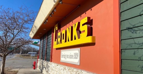 A colorful sign for Cronk's restaurant, featuring the year "1928" and a clear blue sky in the background.