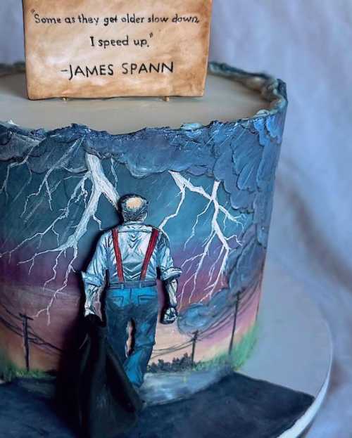 A detailed cake featuring a figure in overalls against a stormy backdrop, with a quote by James Spann on top.