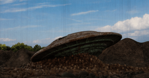 A weathered UFO partially buried in rocky terrain under a blue sky with clouds.
