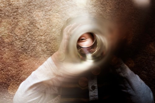 A child peeks through a cylindrical object, with a blurred background creating a dreamy effect.