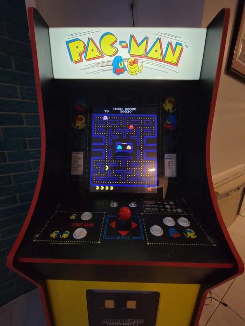 A classic Pac-Man arcade machine displaying the game screen with colorful graphics and controls.